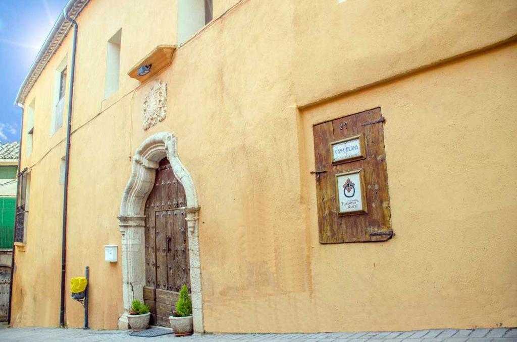 un edificio con una puerta de madera y una ventana en Casa Plana Calasanz, en Calasanz