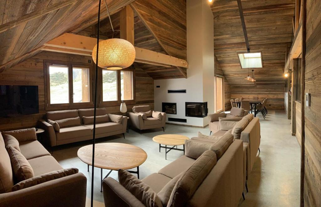 a living room with couches and tables in a building at CAPRICORNE - Chalet sur les pistes avec sauna et home cinema in La Toussuire