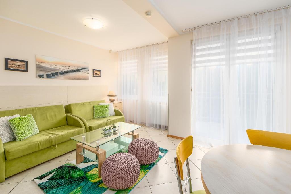 a living room with a green couch and a table at Apartment Bielik A01 by Renters in Międzyzdroje