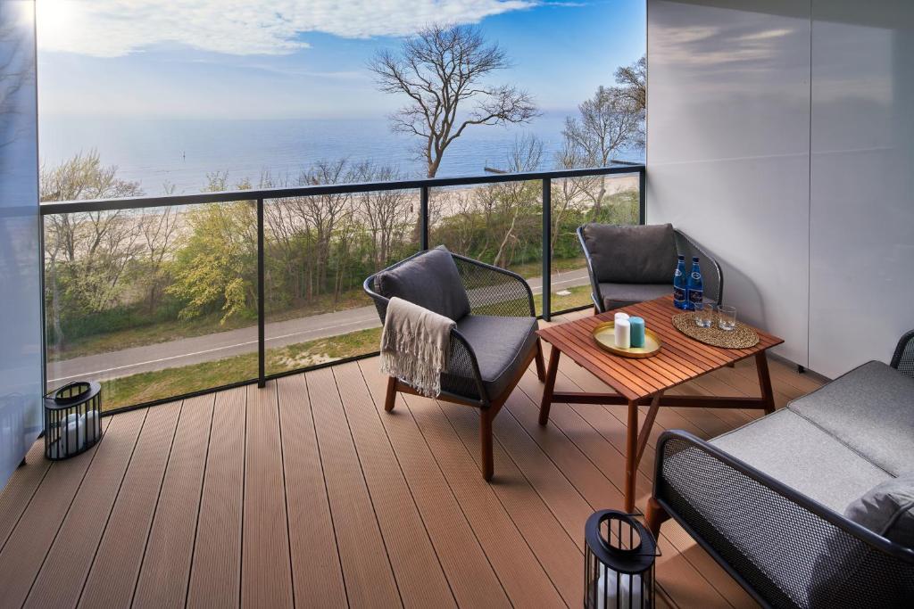 uma varanda com mesa e cadeiras e vista para o oceano em Seaside Park Apartament Prywatny 405 z widokiem na morze em Kolobrzeg