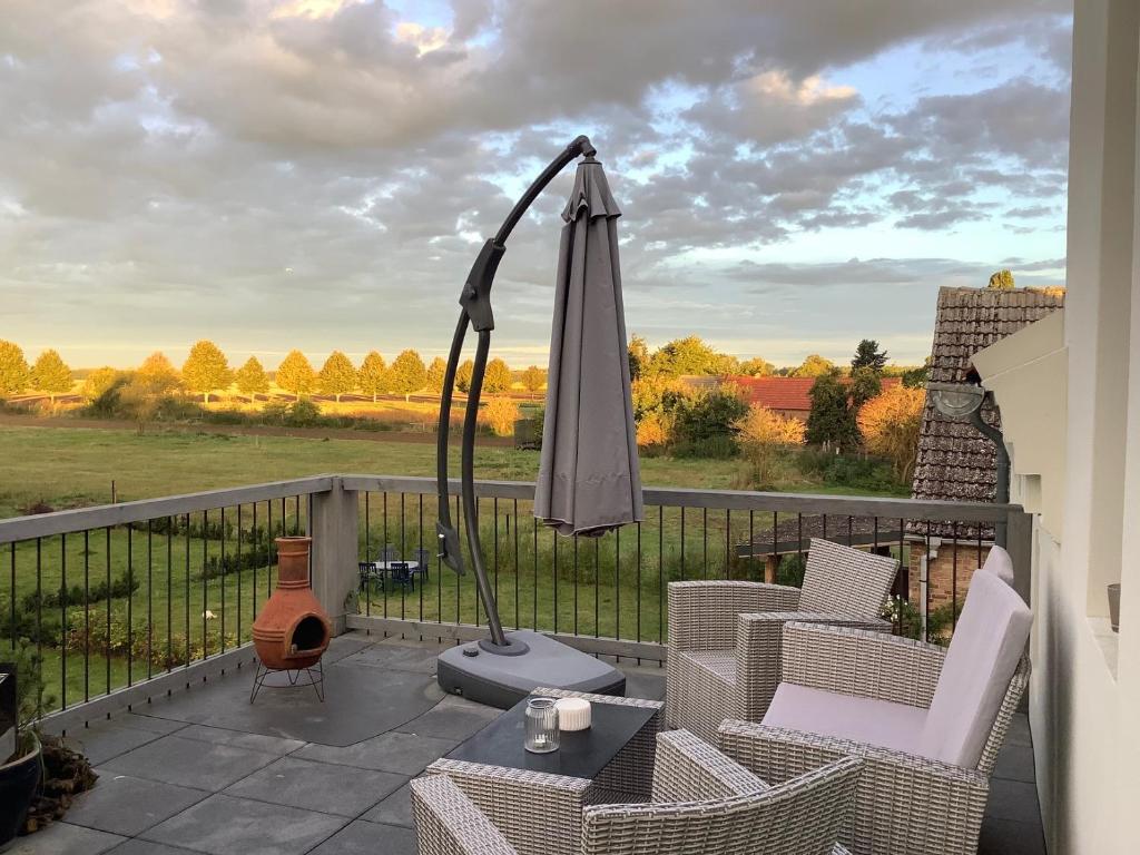 a patio with an umbrella and chairs and a table at Apartment in Buchholz