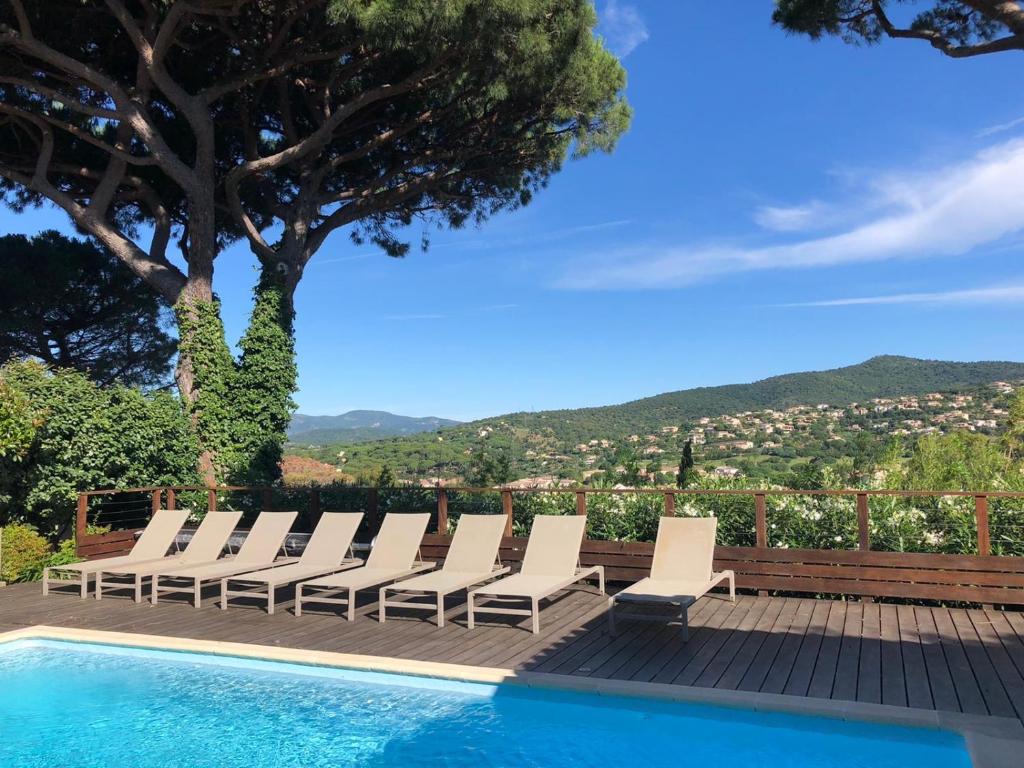 - un groupe de chaises assises à côté de la piscine dans l'établissement villa claire de lune la Nartelle, à Sainte-Maxime