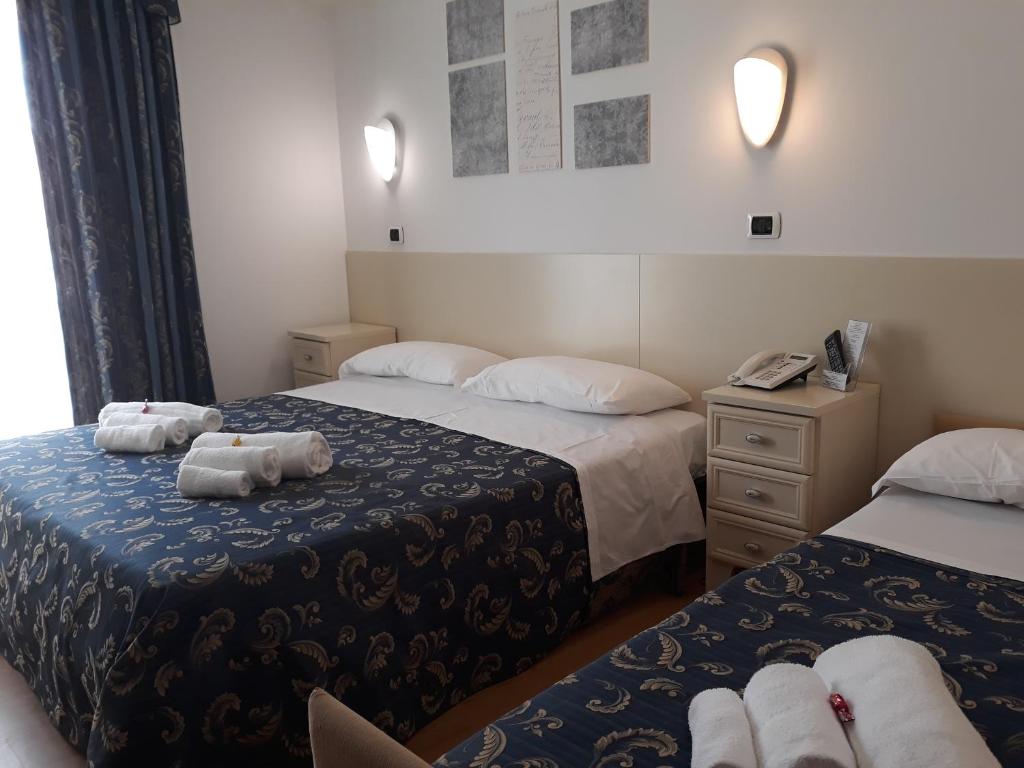 a hotel room with two beds with towels on them at Hotel La Palazzina in San Benedetto del Tronto