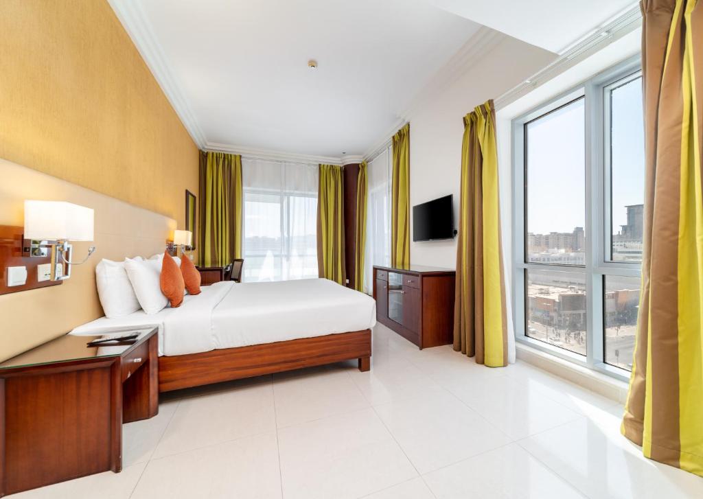 a hotel room with a bed and a large window at Star Metro Deira Hotel Apartments in Dubai