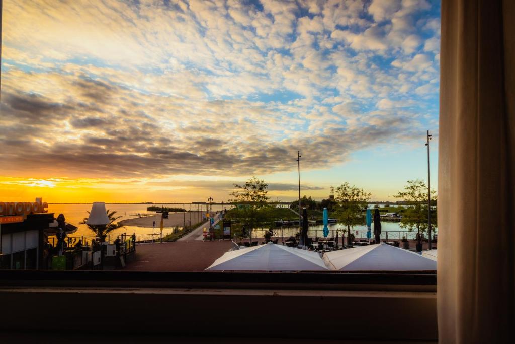 uma vista a partir de uma janela de uma marina ao pôr-do-sol em Hotel Bella Ciao em Harderwijk