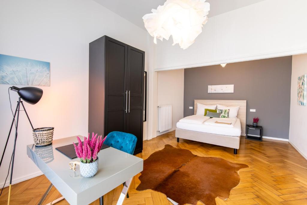 a bedroom with a bed and a desk and a table at Luxstay Bad Nauheim - Self-Check-In in Bad Nauheim