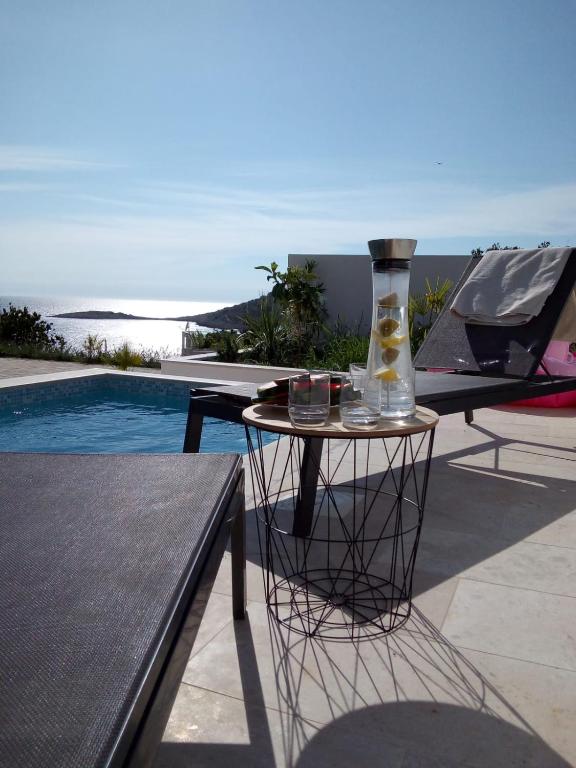 a table with a vase on it next to a pool at Vila Hrvatska in Ražanj