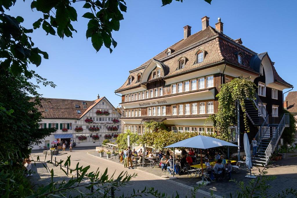 eine Gruppe von Personen, die außerhalb eines Gebäudes sitzen in der Unterkunft Gasthaus Rössli in Mogelsberg