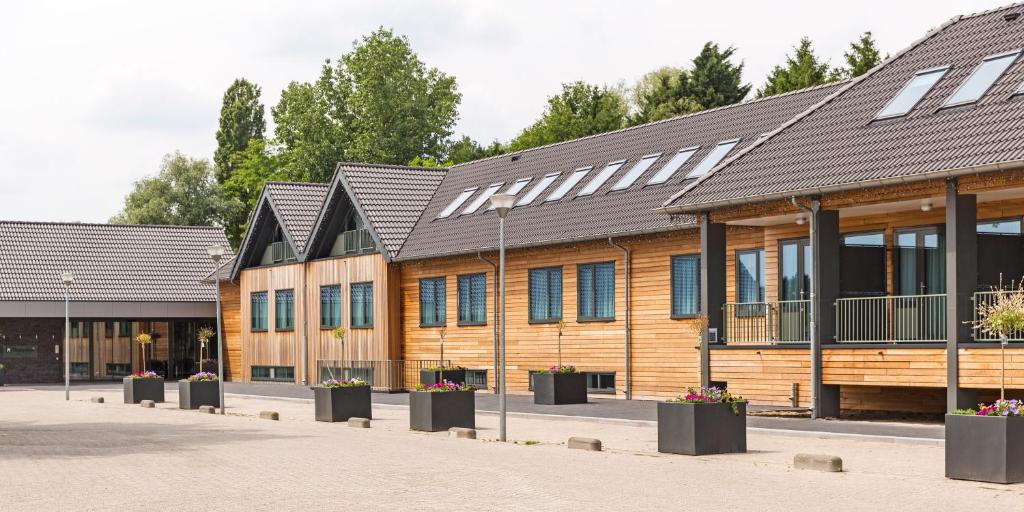 eine Reihe von Holzgebäuden mit Fenstern in der Unterkunft Fletcher Hotel-Restaurant Teugel Uden-Veghel in Uden
