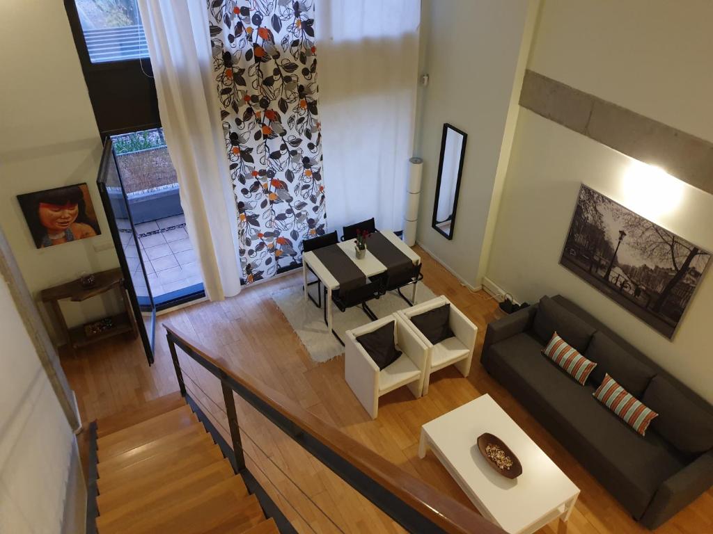 einen Blick über ein Wohnzimmer mit Sofa und Klavier in der Unterkunft Cozy Loft in Tres Cantos, 20 min to Madrid in Tres Cantos