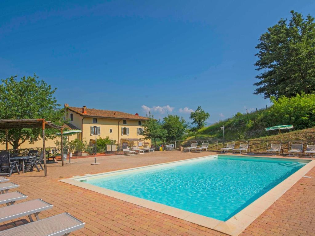 une grande piscine avec des chaises et une maison dans l'établissement Apartment Alba by Interhome, à Serravalle Pistoiese