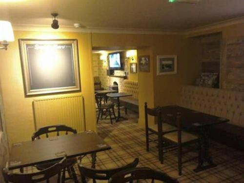 a dining room with tables and chairs in a restaurant at Holland Hotel in Llanfachraeth