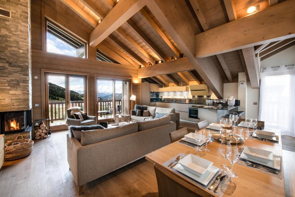 een grote woonkamer met een bank en een tafel bij Mammoth Lodge by Alpine Residences in Courchevel