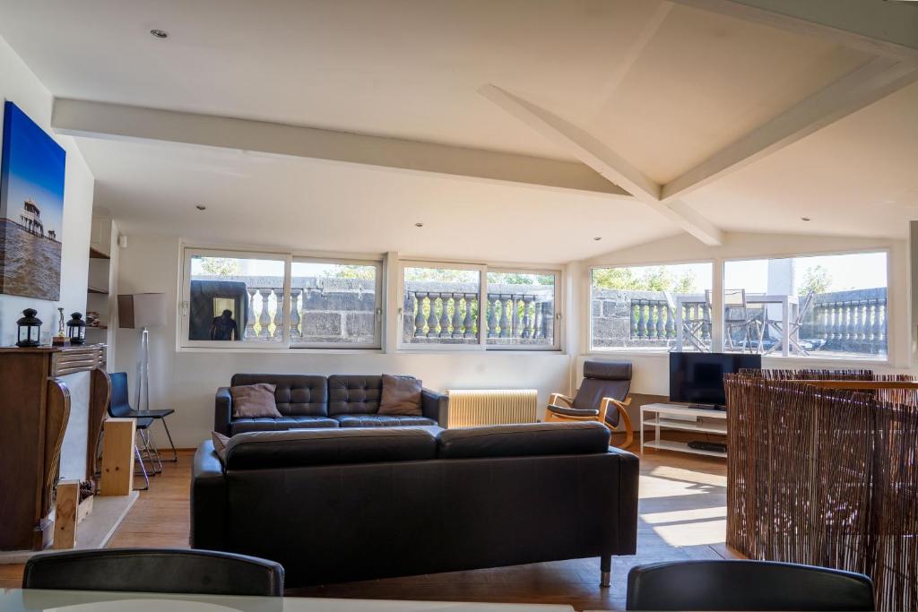 un salon avec un canapé et une télévision dans l'établissement Chateau Trompette - Localisation exceptionnelle 4 chambres 2 salles de bain et grande terrasse, à Bordeaux