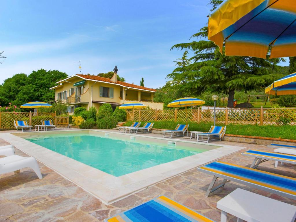 - une piscine avec des chaises et des parasols à côté d'une maison dans l'établissement Apartment Oleandro by Interhome, à La Cava