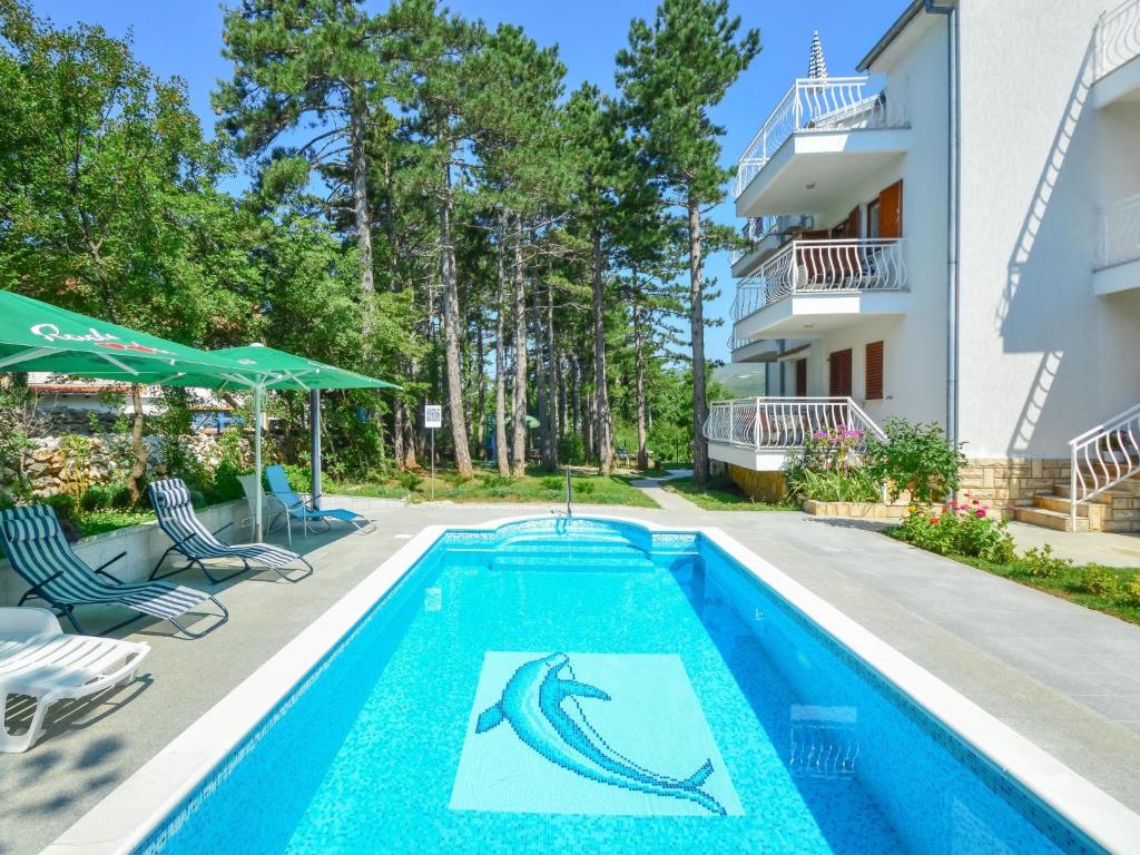 a swimming pool with a fish stencil on the side of a building at Apartment Fuma-6 by Interhome in Jadranovo