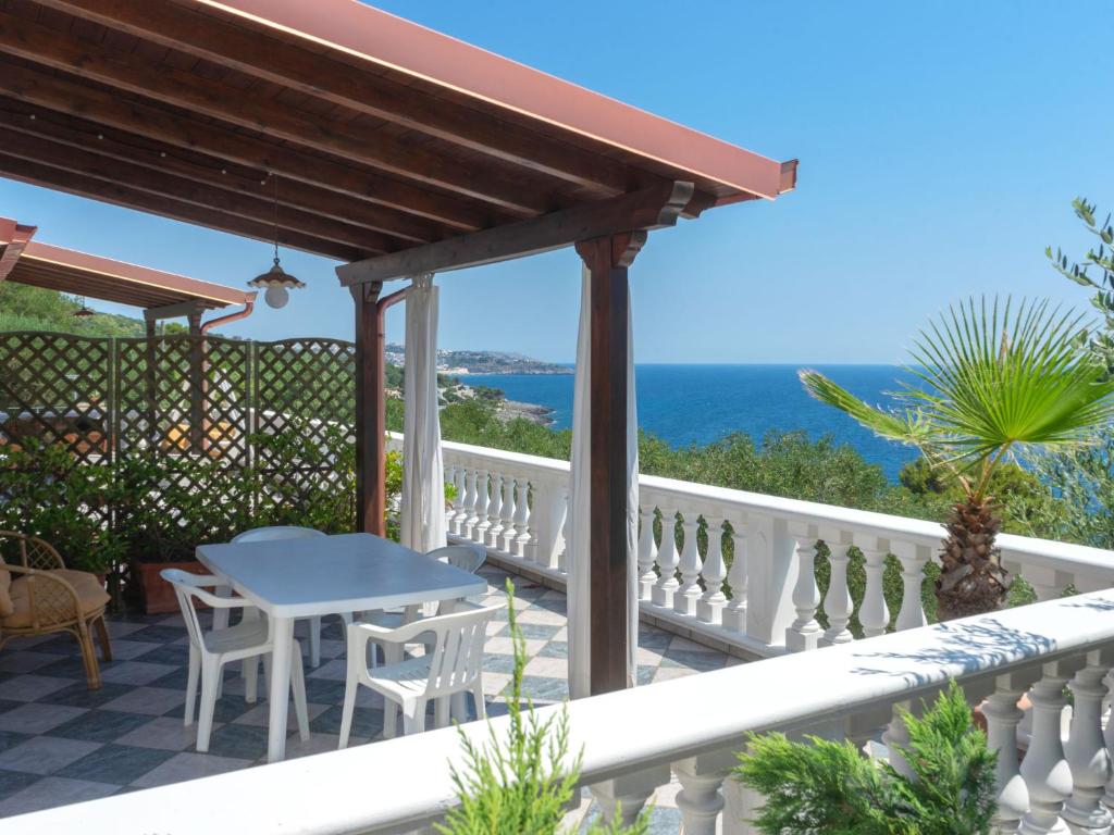 een balkon met een tafel en stoelen en de oceaan bij Apartment Villa Anna-2 by Interhome in Andrano