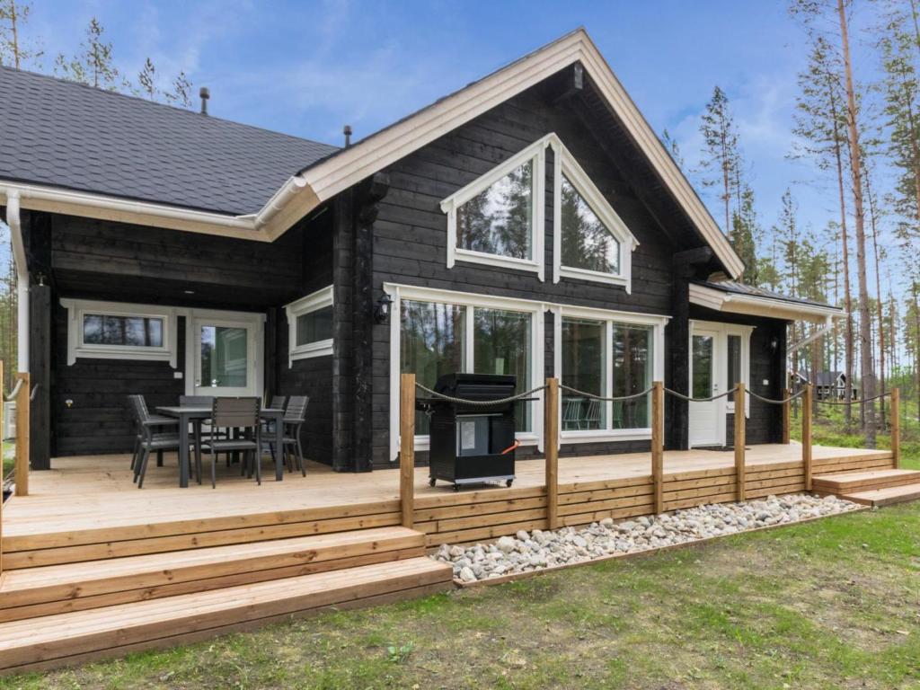 a house with a deck and a grill on it at Holiday Home Miilu by Interhome in Jyrkkä