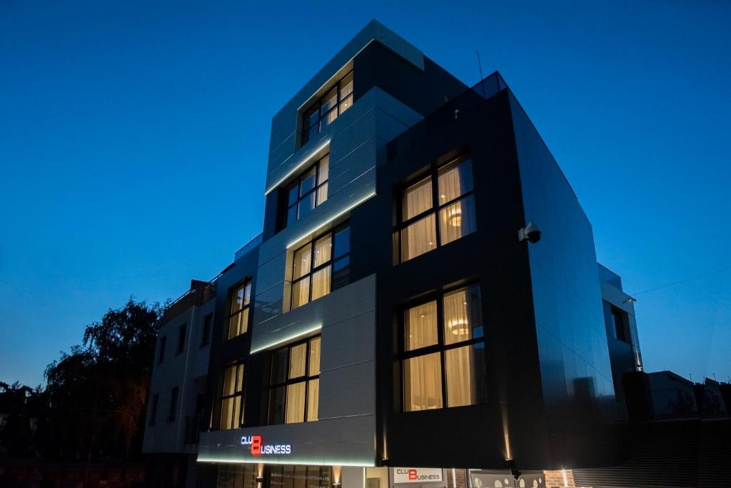 een blauw gebouw met verlichting in de ramen bij Family Hotel Business Club in Shumen