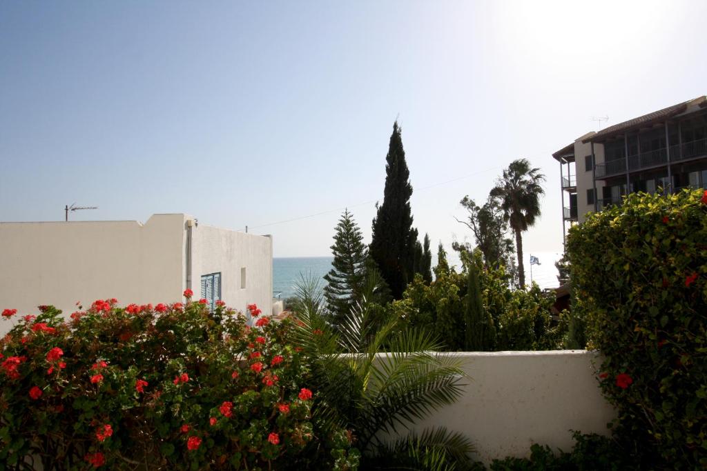 a view of a garden with flowers and buildings at Pissouri Beach Apartments in Pissouri