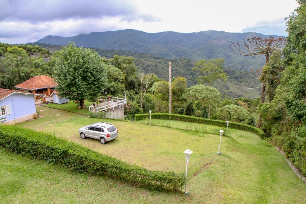 una macchina parcheggiata in un cortile accanto a una casa di Parece um sonho - Campos do Jordão - waze a Campos do Jordão