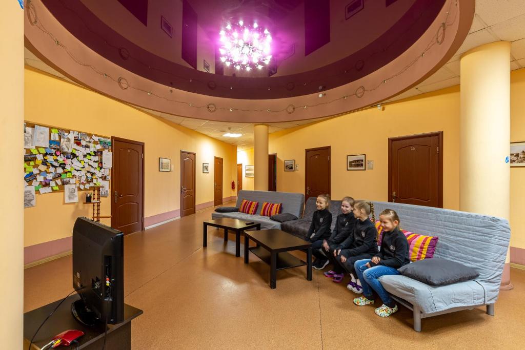 un grupo de niños sentados en un sofá en una sala de espera en Bugrov Hostel, en Nizhny Novgorod