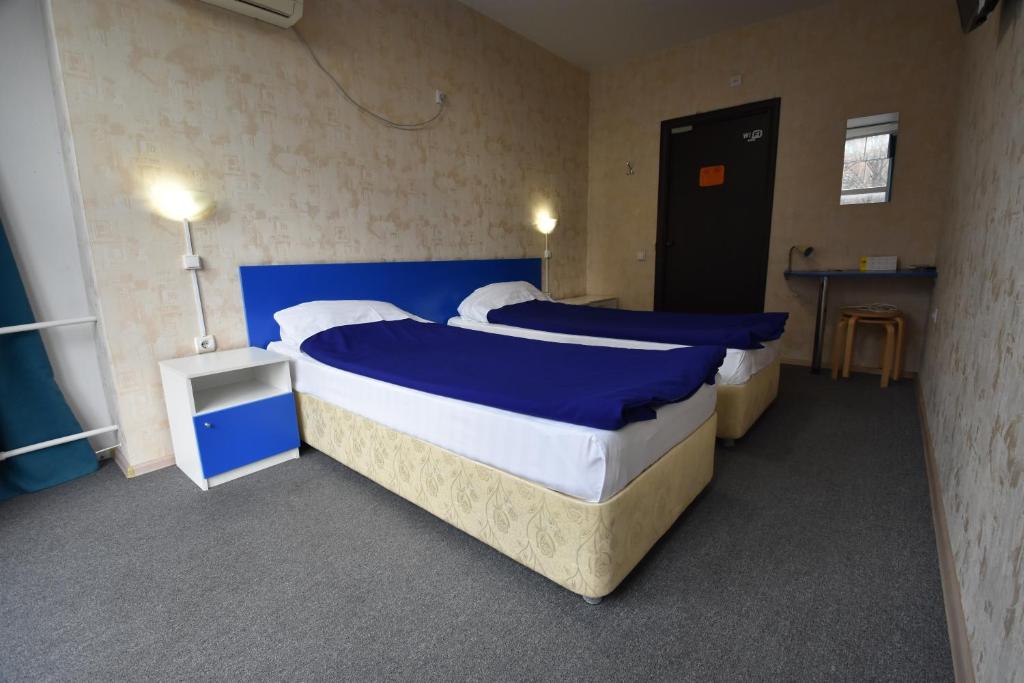 1 dormitorio con 2 camas con sábanas azules y blancas en ID Hostel Rostov-on-Don, en Rostov-on-Don