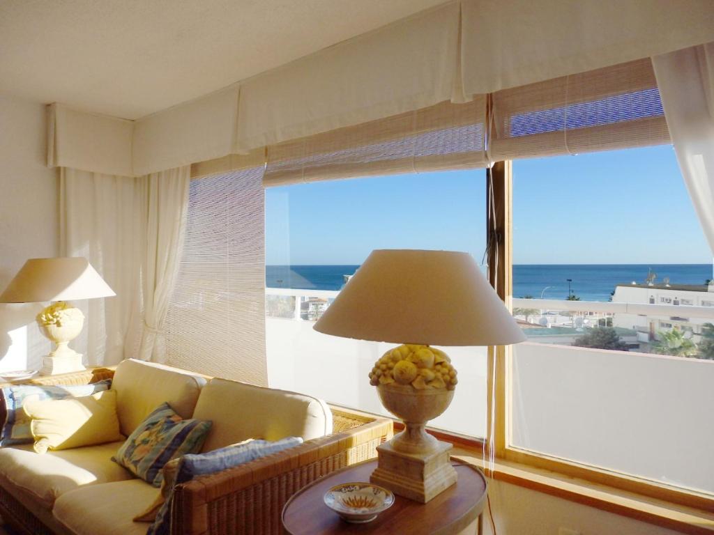 sala de estar con sofá y mesa con lámpara en playamar, en Torremolinos