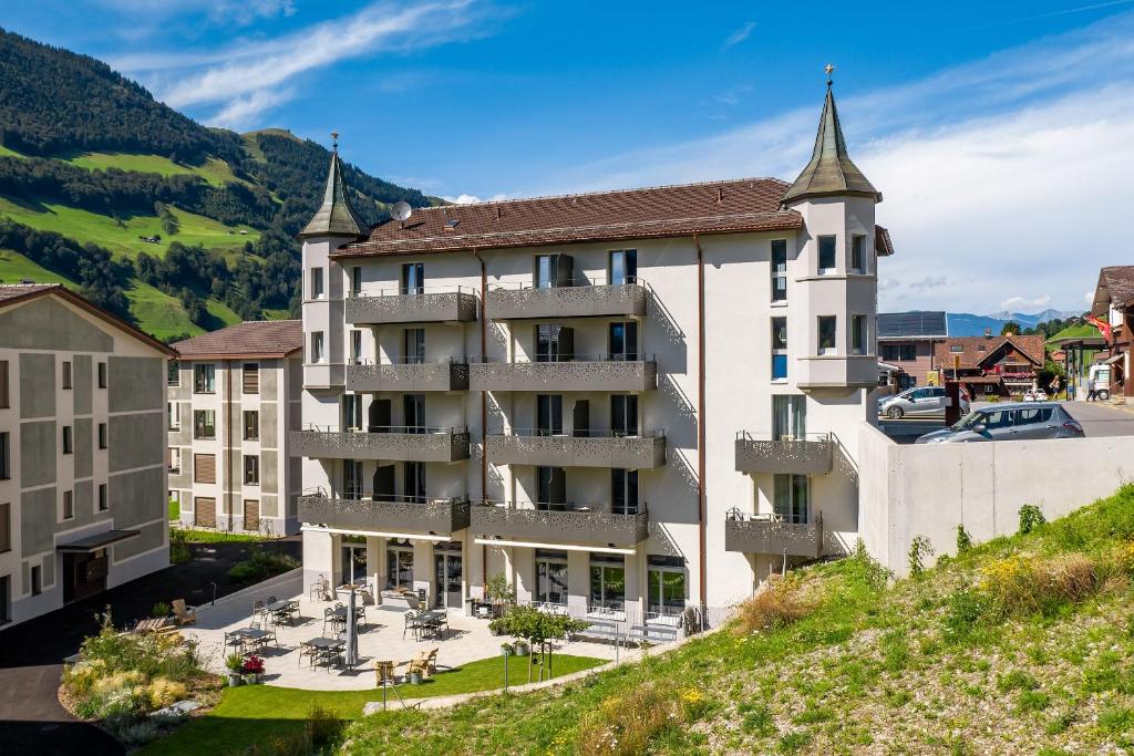 an image of a building with mountains in the background at Emma's B&B - Self Check-in Hotel in Lungern