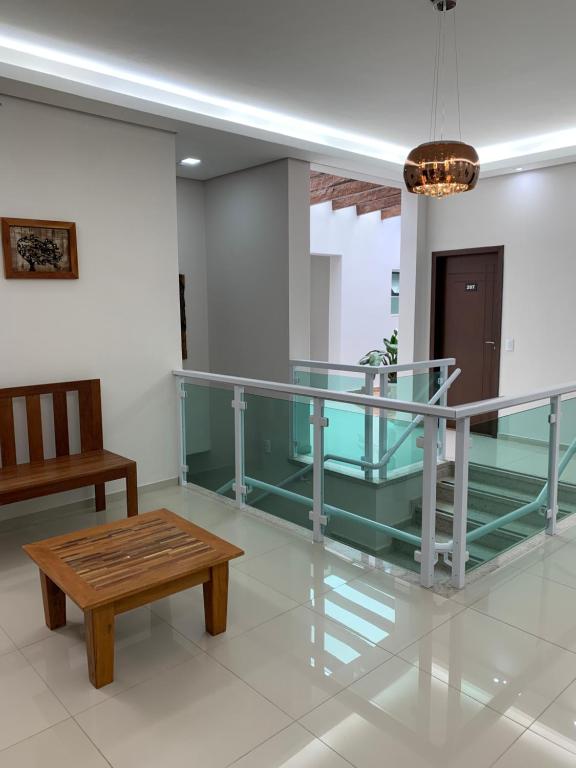 uma mesa de vidro e um banco num quarto em Hotel Aliança Barbacena em Barbacena