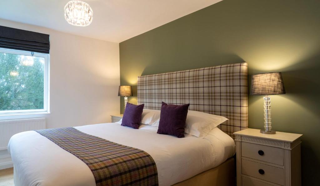 a bedroom with a large bed with purple pillows at The Garden House B&B in Bristol