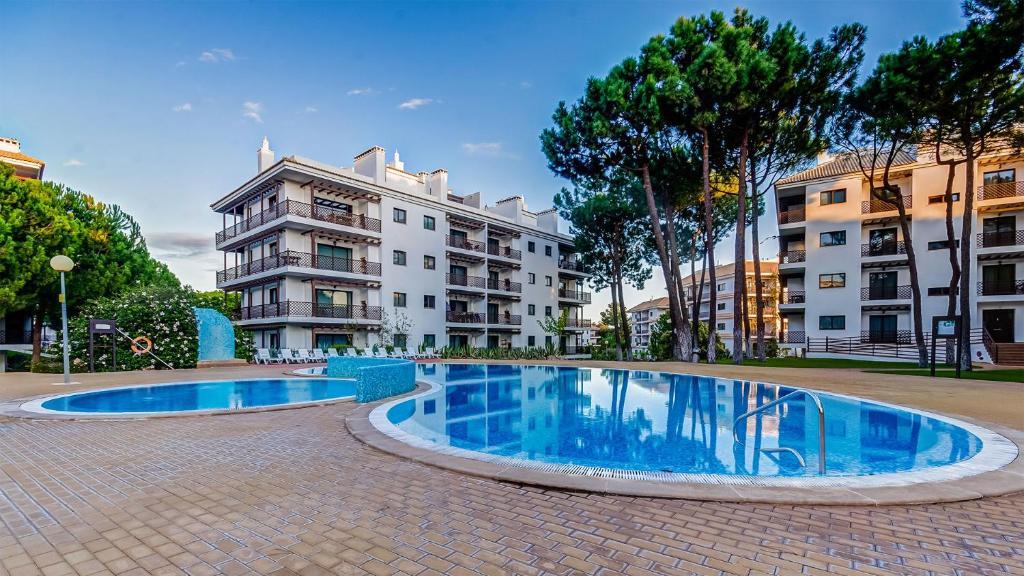 a swimming pool in the middle of a street with buildings at Praia da Falésia - Falesia Beach - Apartment Netflix and HBO in Albufeira