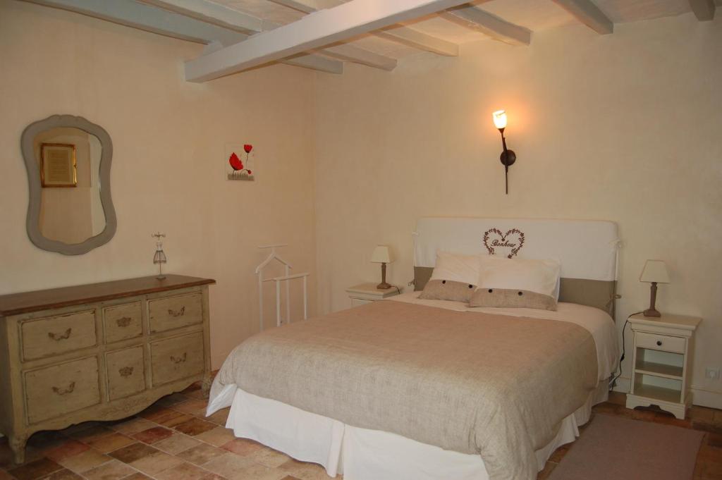 1 dormitorio con cama, tocador y espejo en La Grange Dîmière, près de Tours, en Saint-Genouph