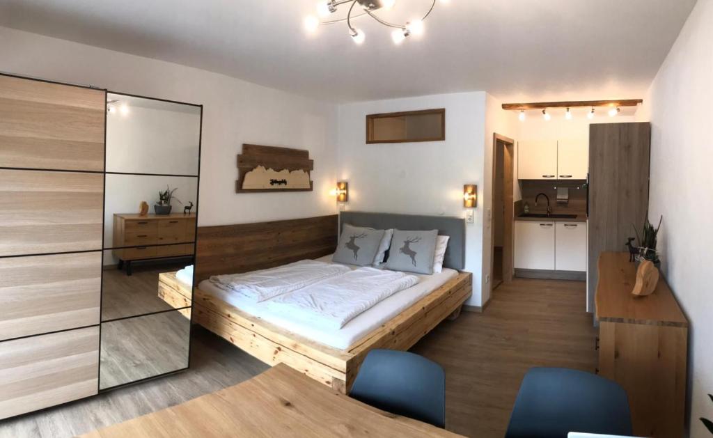 um quarto com uma cama e duas cadeiras azuis em Berghof Apartment Bergwiese Top 31 em Ellmau