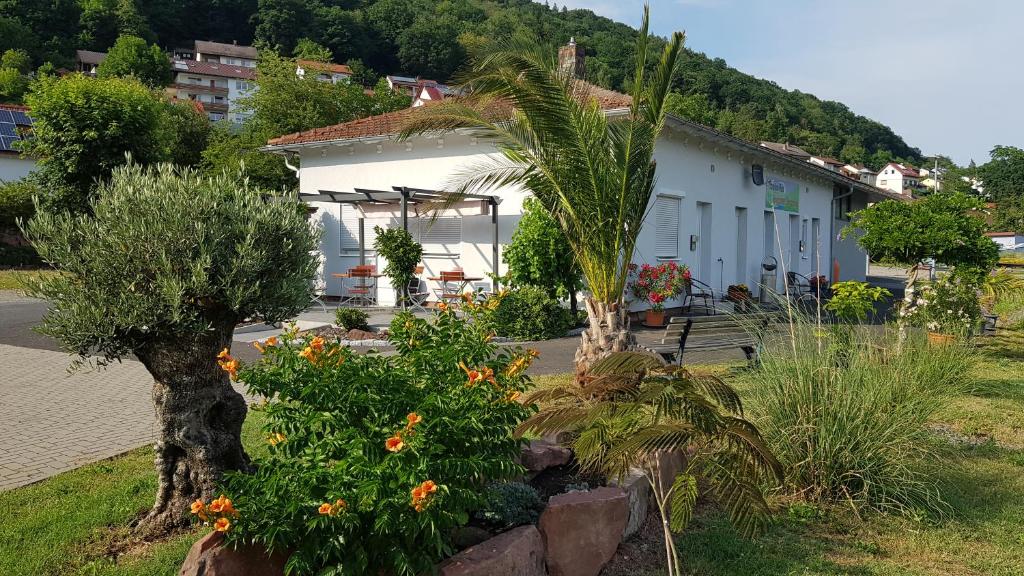 biały budynek z drzewami i kwiatami na dziedzińcu w obiekcie Travelers Home w mieście Hasloch