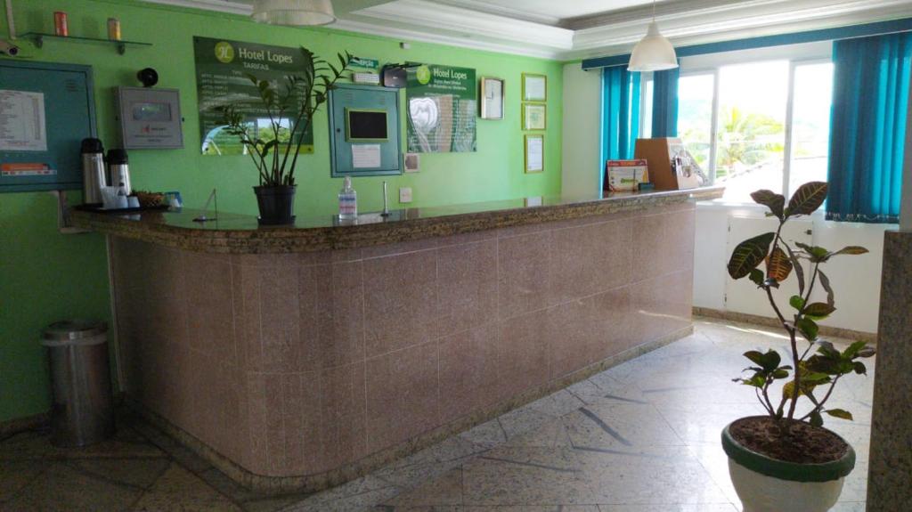 a bar in a restaurant with a potted plant at Hotel Lopes in Cubatão