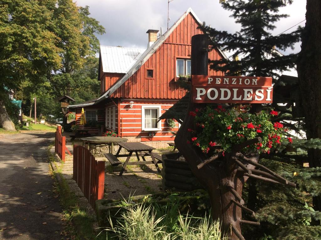 a sign in front of a log cabin at penzion Podlesí in Kořenov