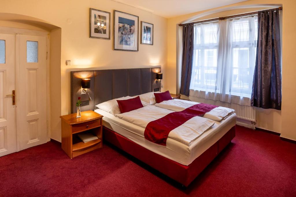 ein Schlafzimmer mit einem großen Bett und einem Fenster in der Unterkunft Pension U Lilie in Prag
