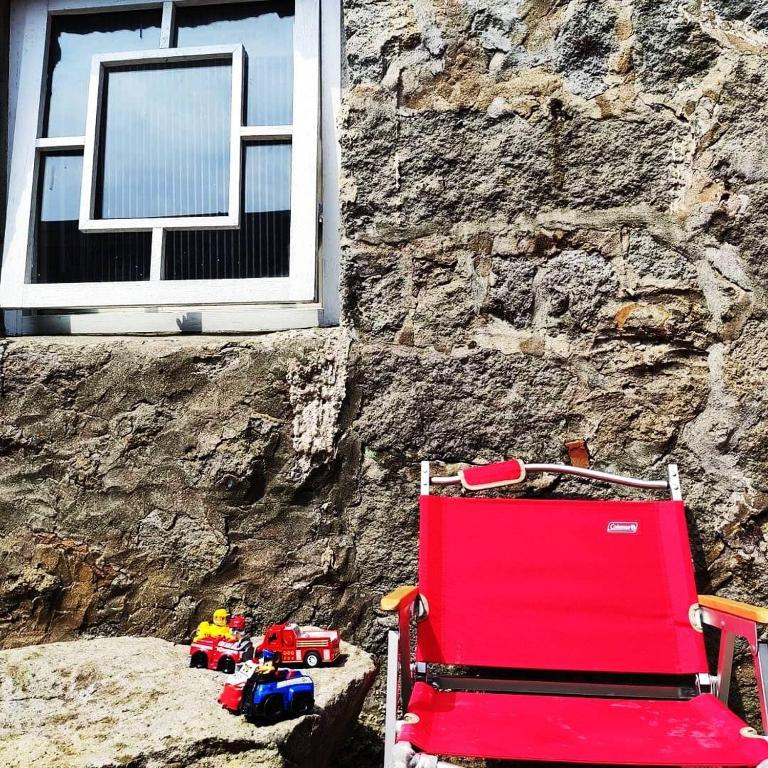 a red chair and toys in front of a building at Taipei Jinguashi Cloud Mountain Homestay B&amp;B in Jiufen