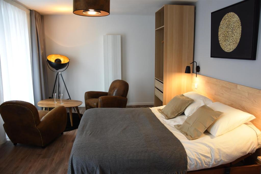 a hotel room with a bed and a chair at nuit sur le pont 3 in Landerneau