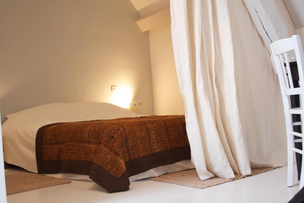 a bedroom with a bed and a ladder at La Petite Maison d'à Côté in Saint-Aignan