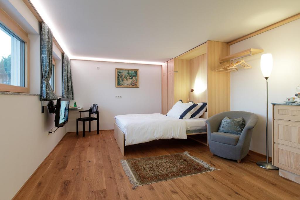 a hotel room with a bed and a chair at Business Apartment in Schwarzach