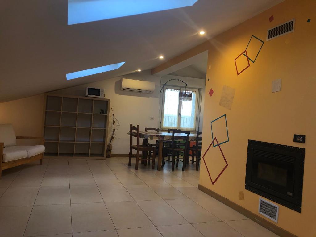 sala de estar con chimenea y comedor en Appartamento mansardato en San Giorgio Di Mantova