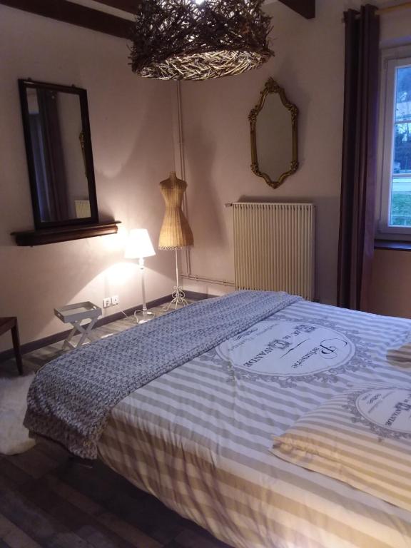 - une chambre dotée d'un lit avec une couverture bleue et blanche dans l'établissement Laissey-vous tenter, à Laissey