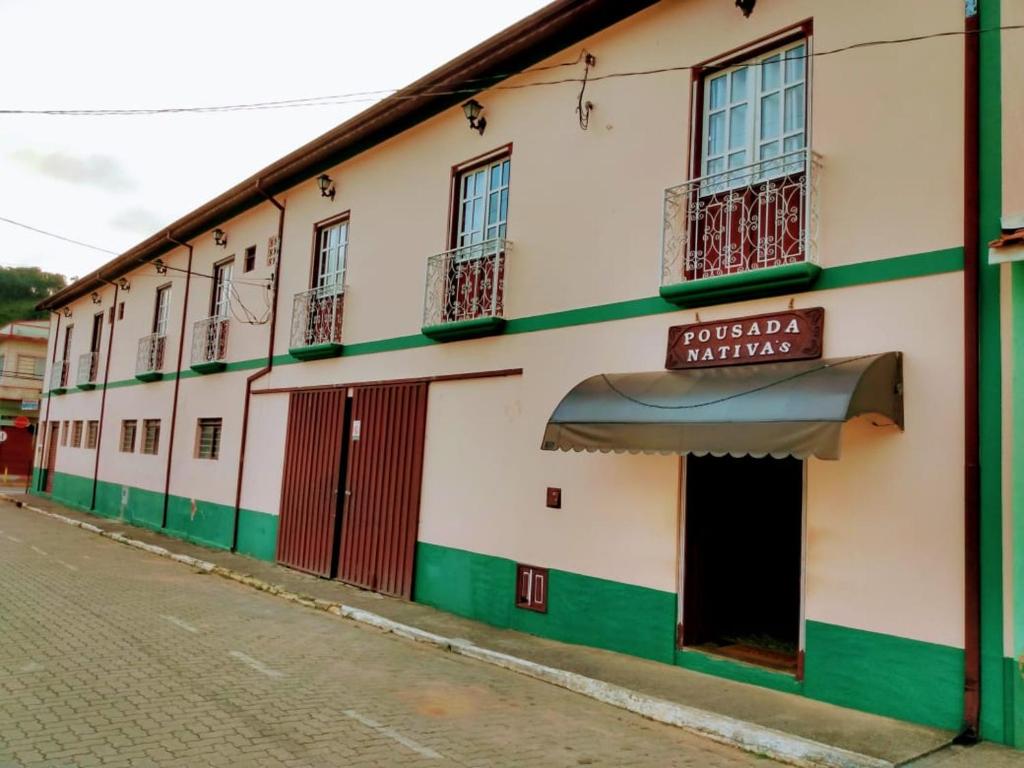 Biały i zielony budynek z napisem w obiekcie Pousada Nativa's w mieście São Luiz do Paraitinga
