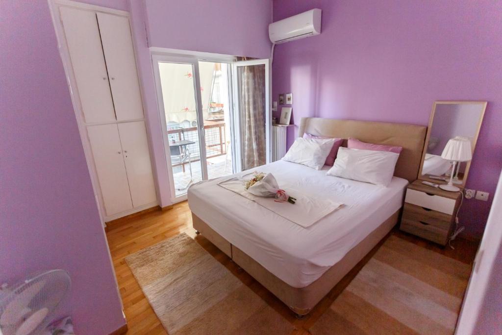 a bedroom with purple walls and a bed with a stuffed animal on it at Peonios Apartment in Athens