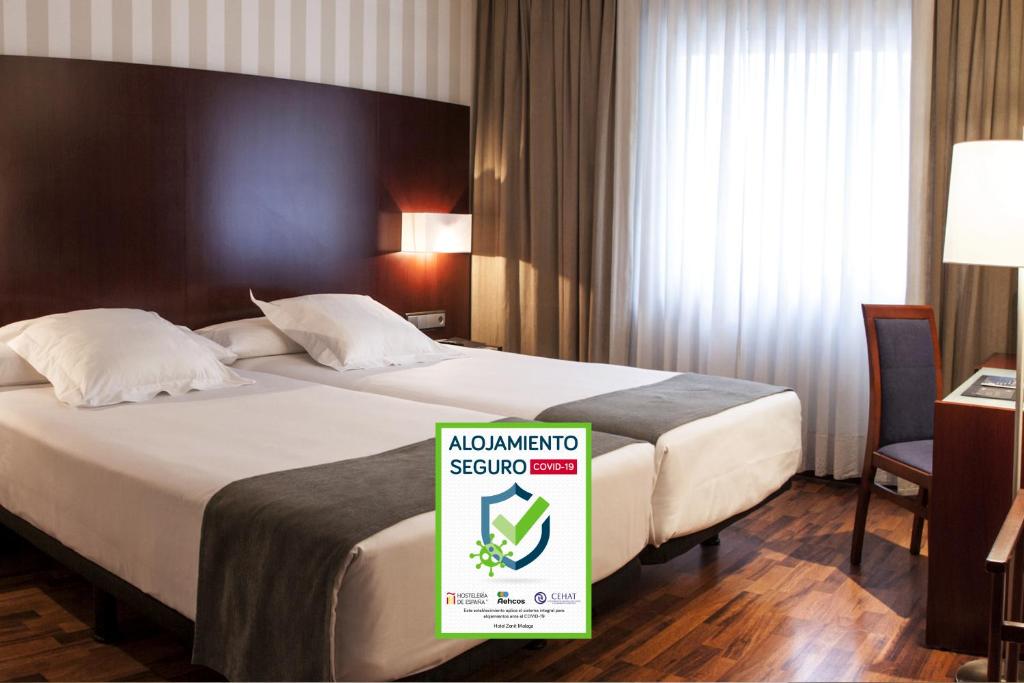 una habitación de hotel con una cama grande con un cartel. en Zenit Málaga, en Málaga