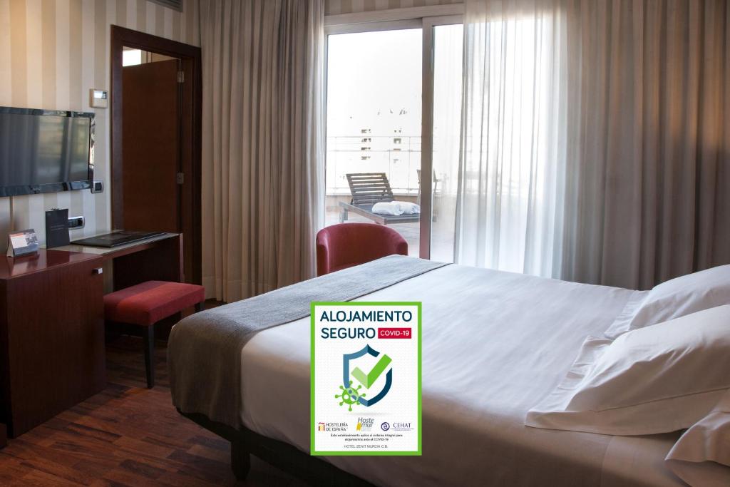 a hotel room with a bed with a sign on it at Zenit Murcia in Murcia