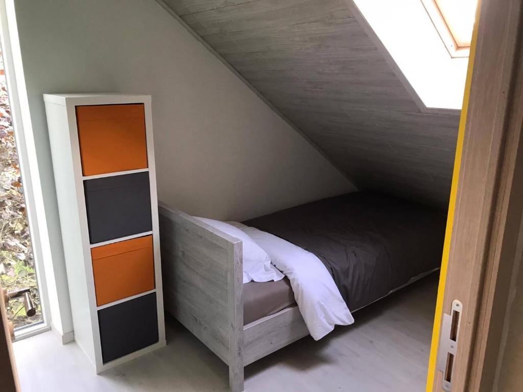 małą sypialnię z łóżkiem i lustrem w obiekcie NGI Vacances w mieście Malmedy