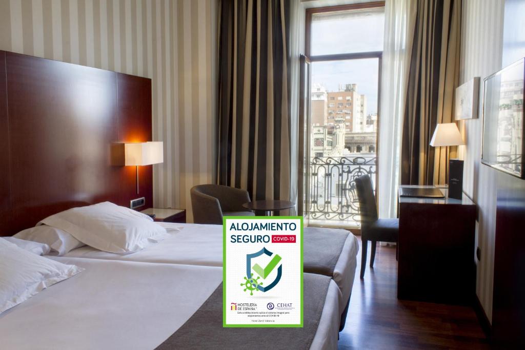 a hotel room with a sign on a bed at Zenit Valencia in Valencia